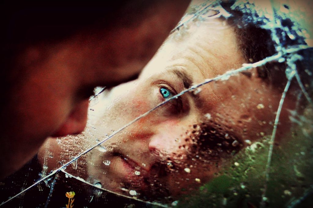 Looking into a cracked mirror, symbolising emotional resilience when healing after betrayal